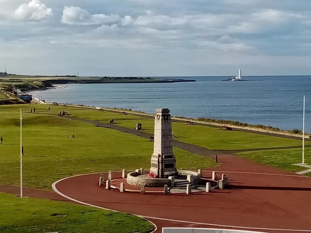 The cenotaph on The Links at Whitley Bay, with St Mary's Lighthouse behind it, where the borough's afternoon parade forms up
